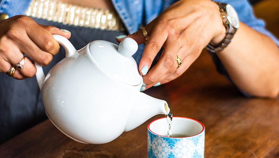 Frau mit Teetasse und Kanne - Symbolfoto